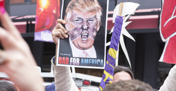SAN DIEGO USA - MAY 27 2016: A protester holds a sign featuring an angry photo of Donald Trump and reading "Bad for America" at an anti-Trump protest outside a Trump rally in San Diego.