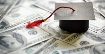 Graduation mortar board cap on one hundred dollar bills concept