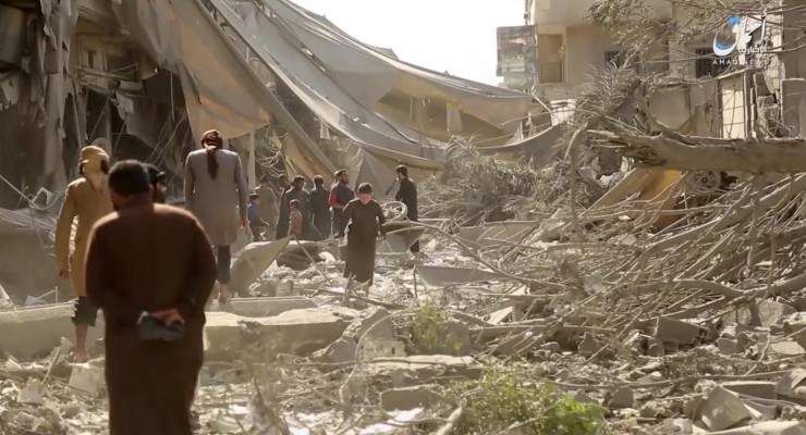 This undated frame grab from video posted online Monday, May 29, 2017, by the Aamaq News Agency, a media arm of the Islamic State group, shows people inspecting damage from airstrikes and artillery shelling in the northern Syrian city of Raqqa, the de facto capital of the IS. Airstrikes have intensified over the past days as U.S.-backed fighters have marched toward the city, getting closer to besieging it from all sides. (Aamaq News Agency via AP)
