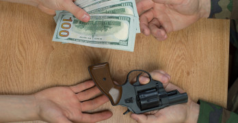 picture showing several large bills in exchange for a revolver